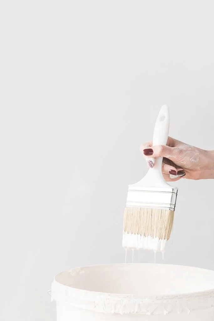 Woman holding brush with white paint