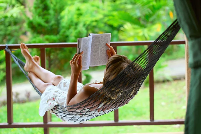 Woman reading near green area