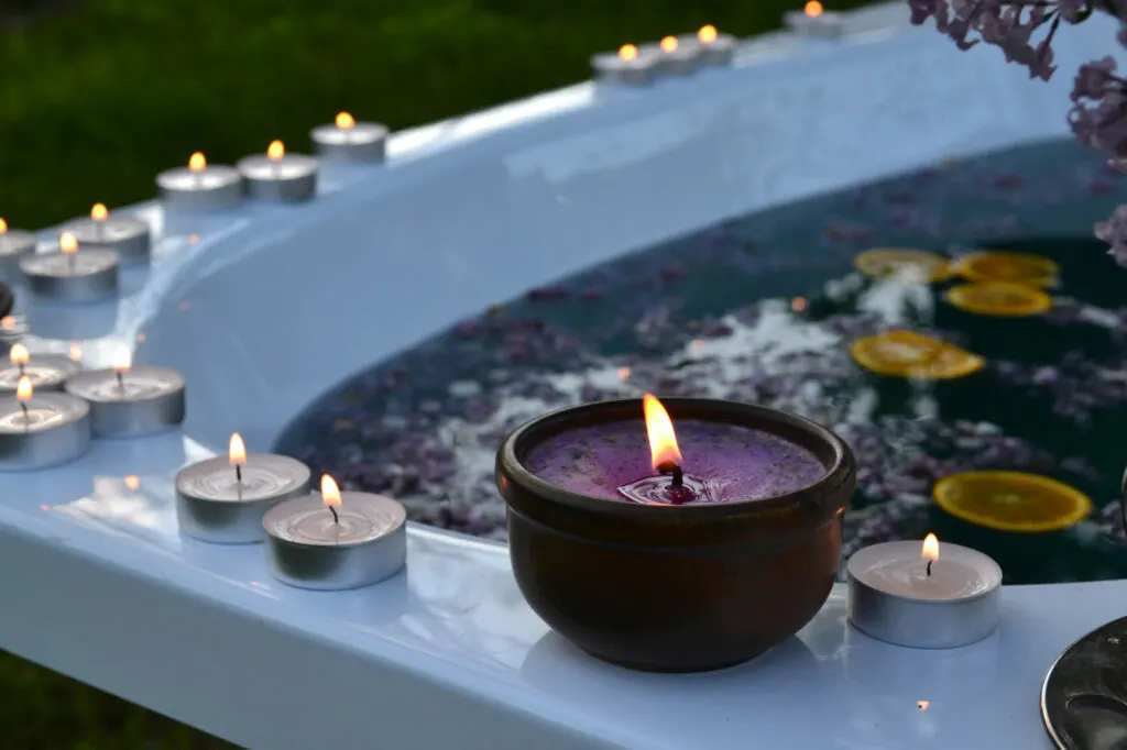 Purple candle on bathtub edge
