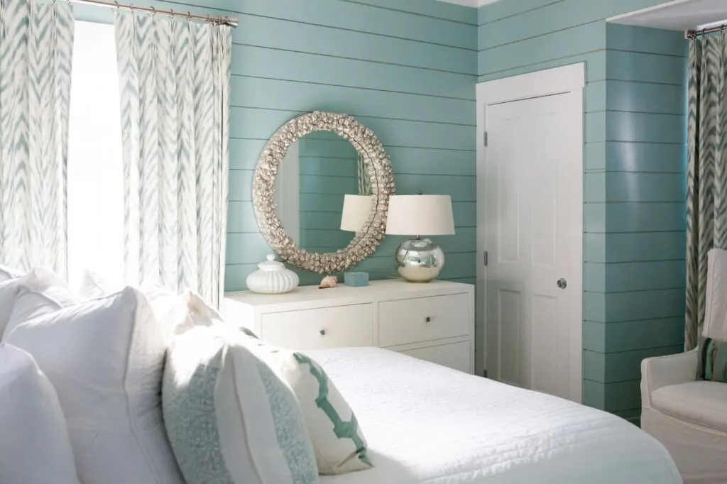 Beach house bedroom wall painted in teal, a relaxing color