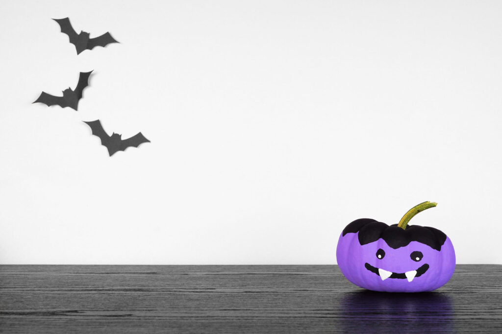 Purple pumpkin with vampire face for Halloween