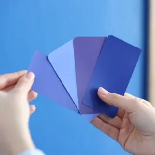 Hands holding different shade, tint, and tone of blue papers