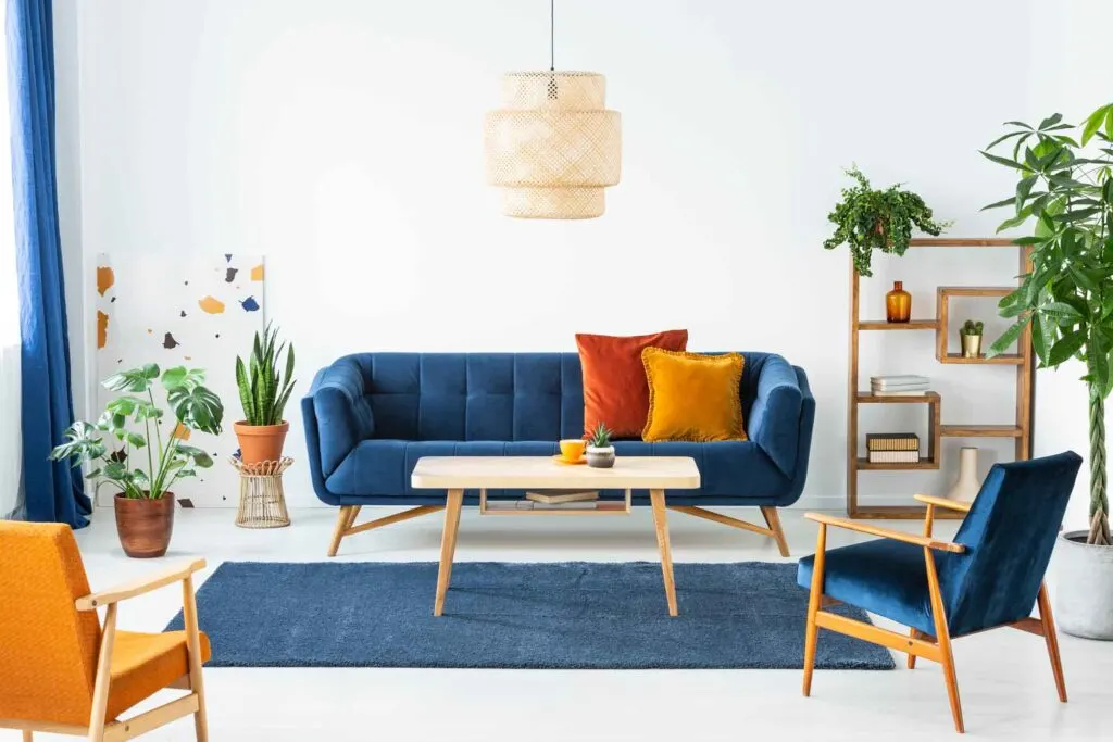 Blue couch with red and orange accents in a white living room