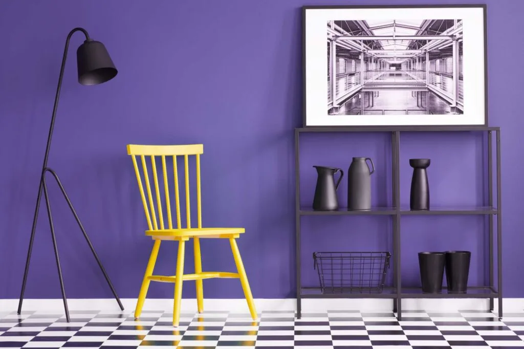 Yellow chair next to purple accent wall