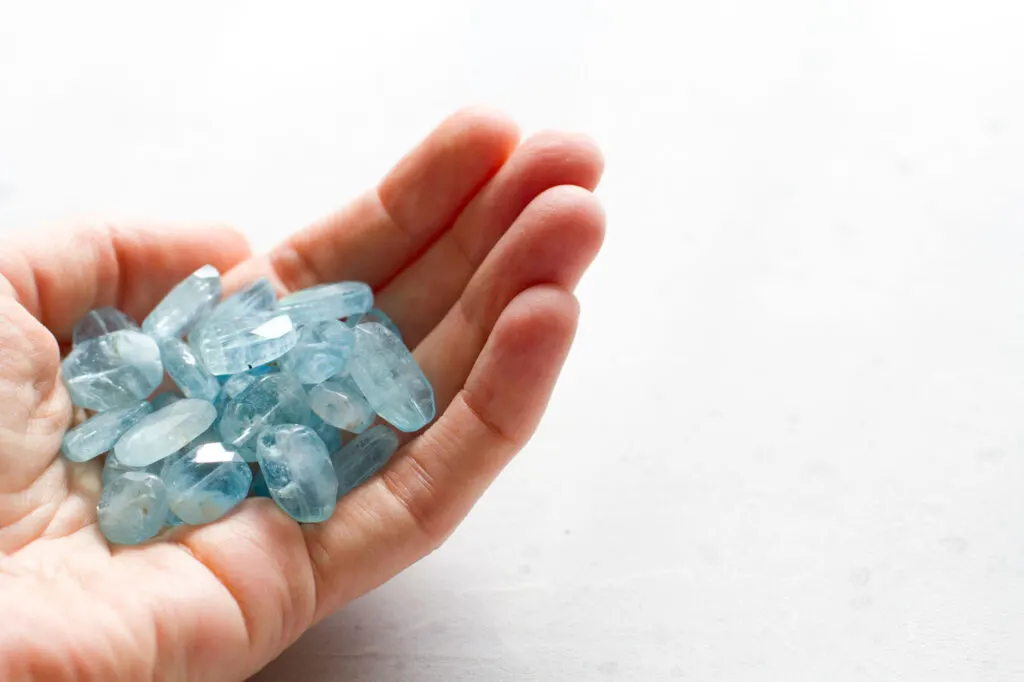 Hand holding blue aquamarine gemstones