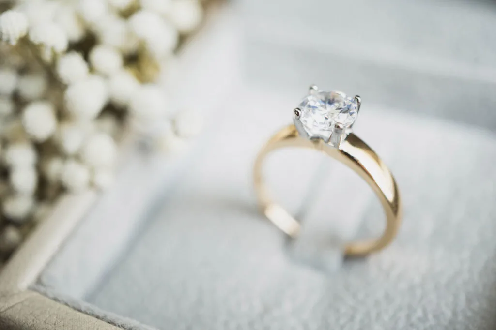 White diamond on golden engagement ring