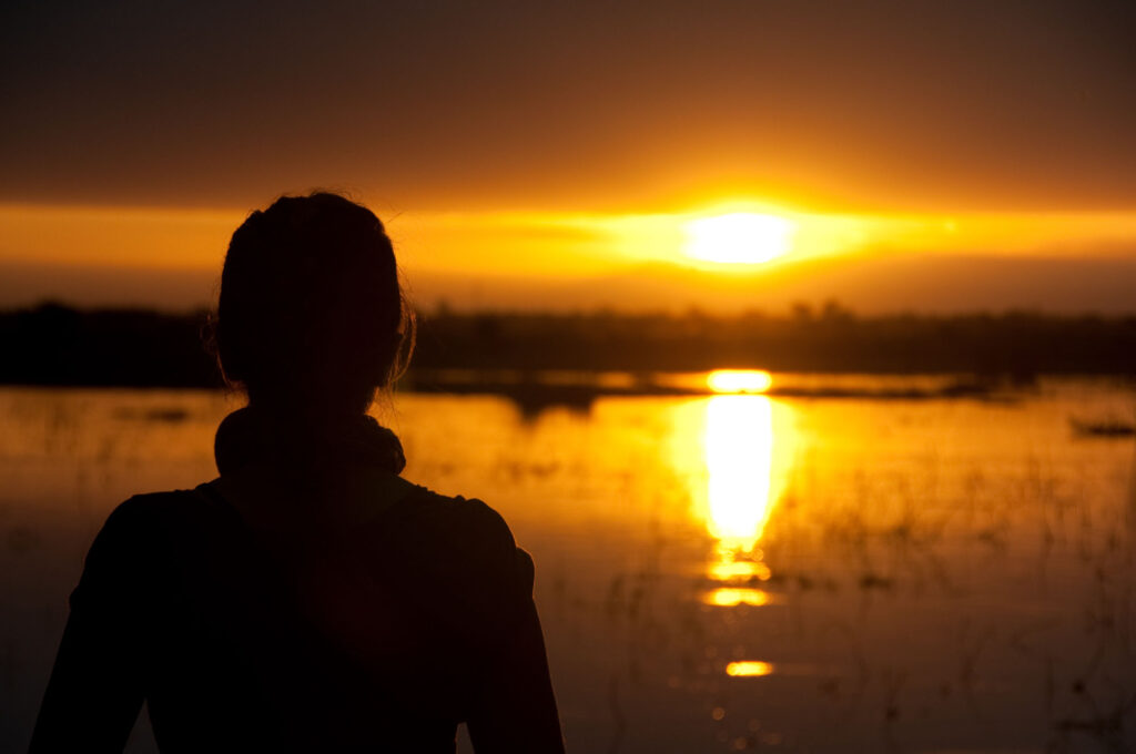 Woman staring at amber sunset