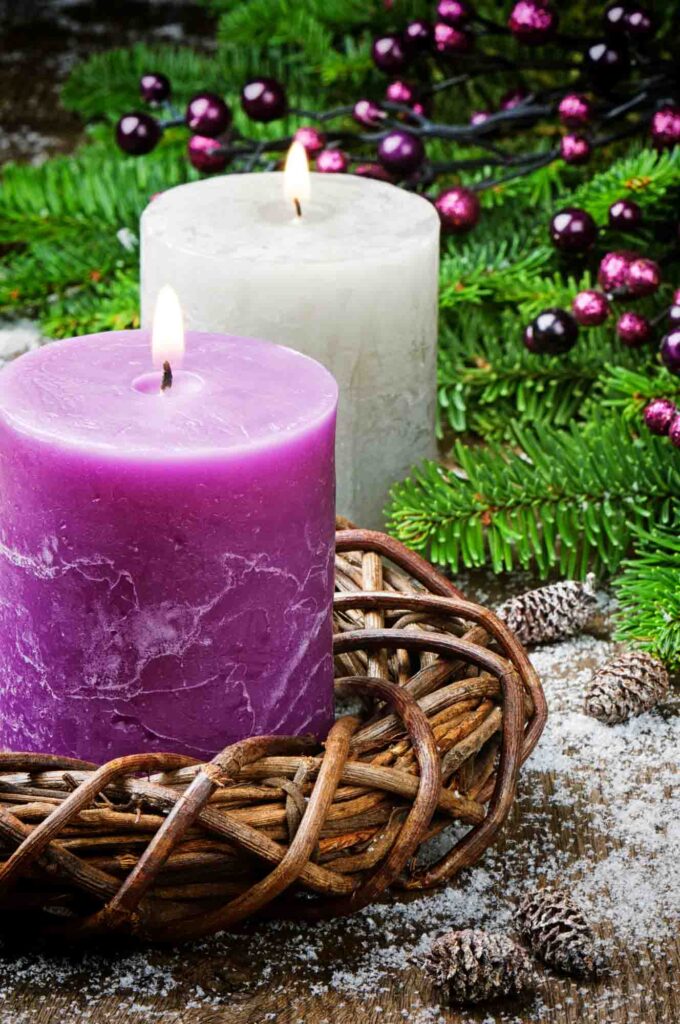 Burning purple candles on festive Christmas background