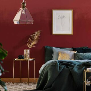 Red bedroom with green blanket with golden furniture