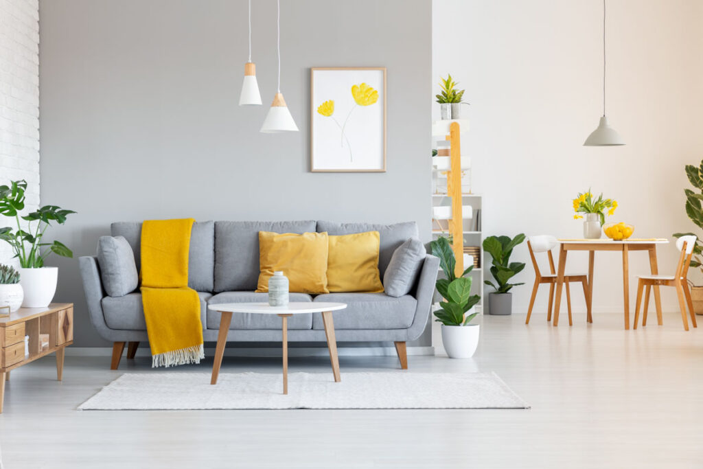 Yellow blanket on gray couch in modern apartment