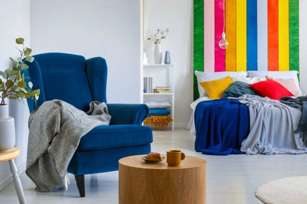 Royal blue chair near neon colors in bedroom